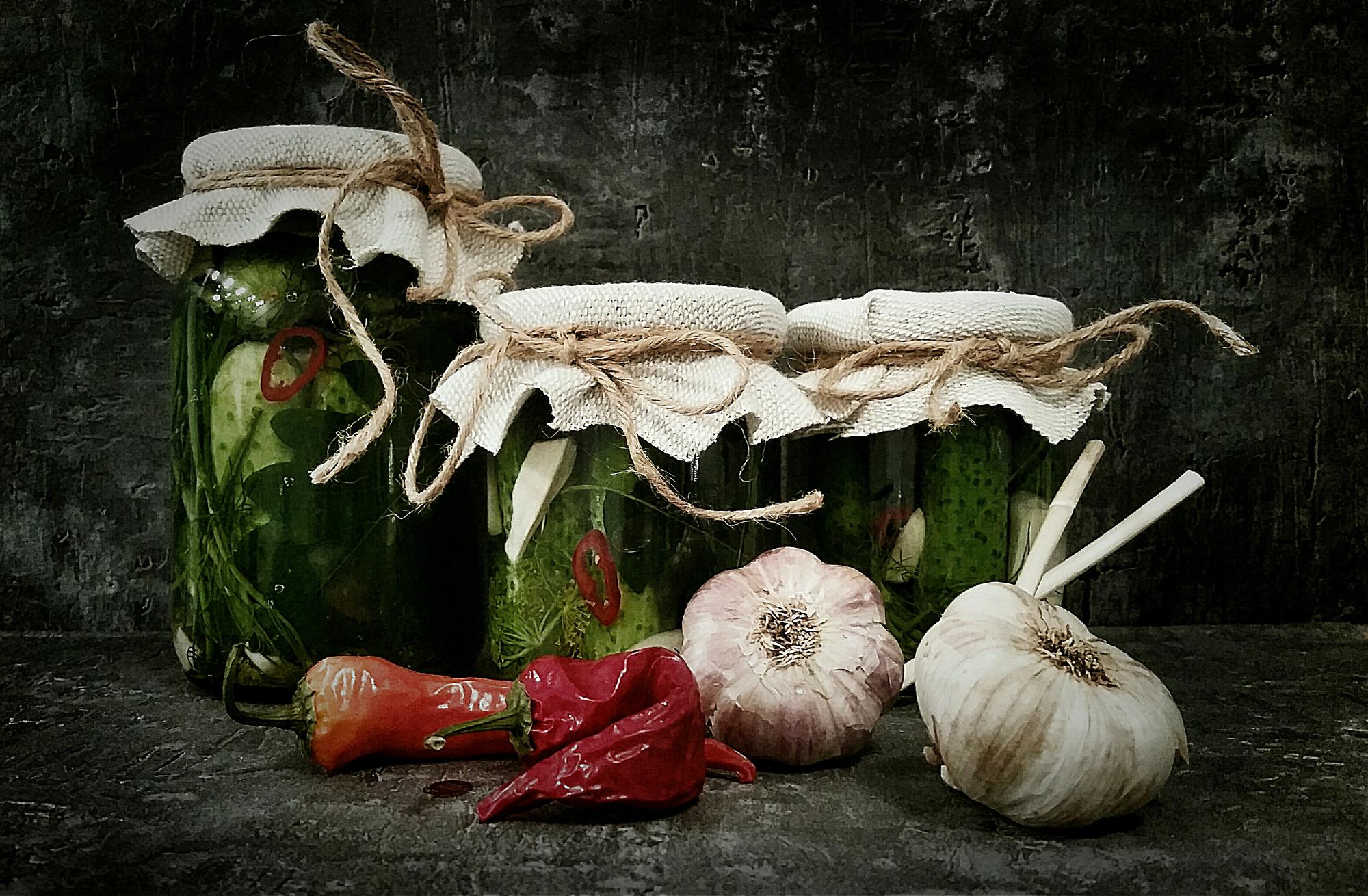 Wooden board with preserved jars and herbs